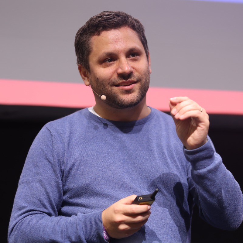 Martin Sakowski speaking on stage at a conference.